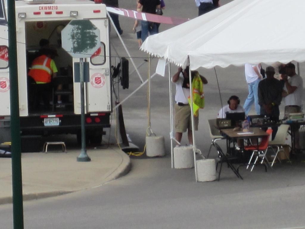 This image is clicked on the roads. To the left, there is ambulance. To the right, there is a tent...