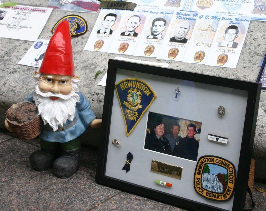 In this image there is a toy Santa Claus, there are badges and a photo in a photo frame, and in the...