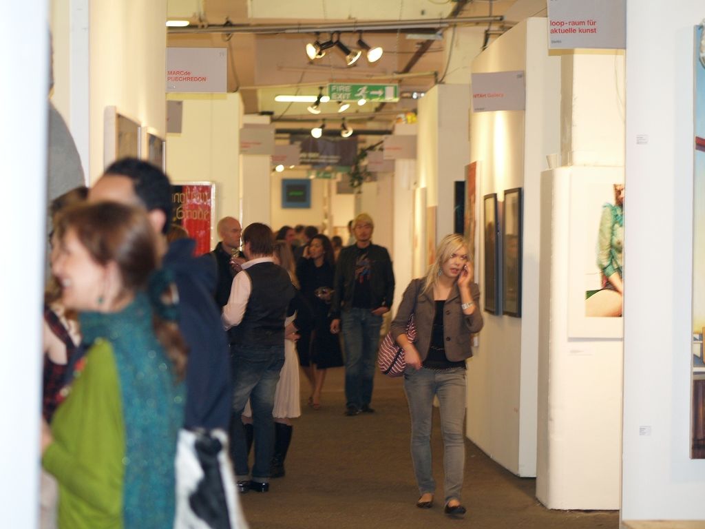 In this picture there are group of people walking and there is a woman holding the device and...