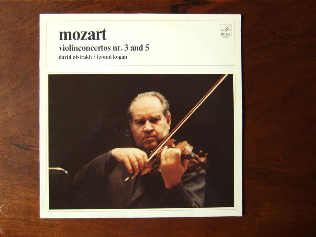 In this picture there is a photograph placed on a wooden table. In the front we can see a man...