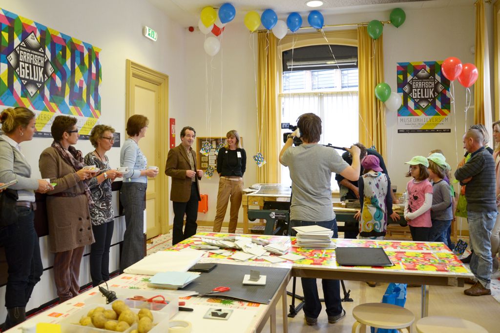 This picture is taken inside a room. It looks like a celebration. There are people in the room....