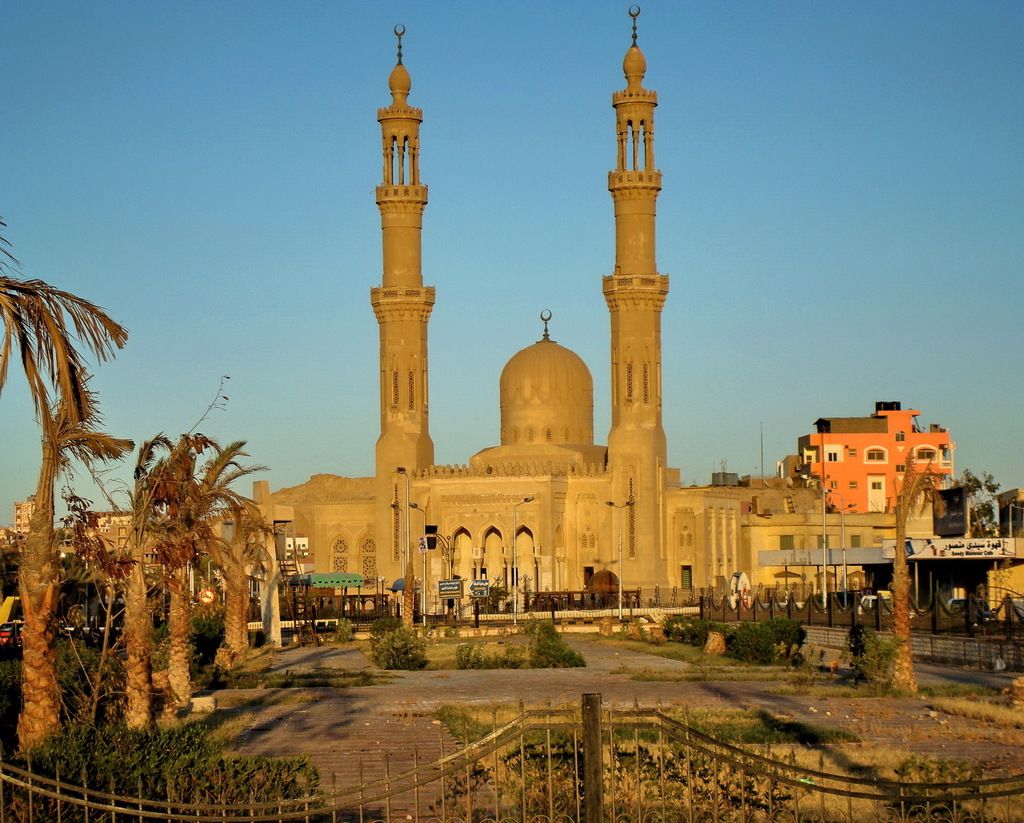 In this image in the center there is one mosque, and in the background there are some buildings. On...