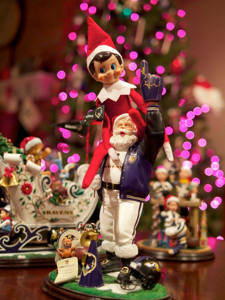 In the foreground of the image there are toys. In the background of the image there is a Christmas...