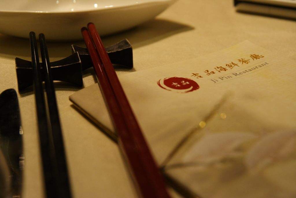 A table on which there is a menu card which is titled in mandarin and English. It is labelled as ji...