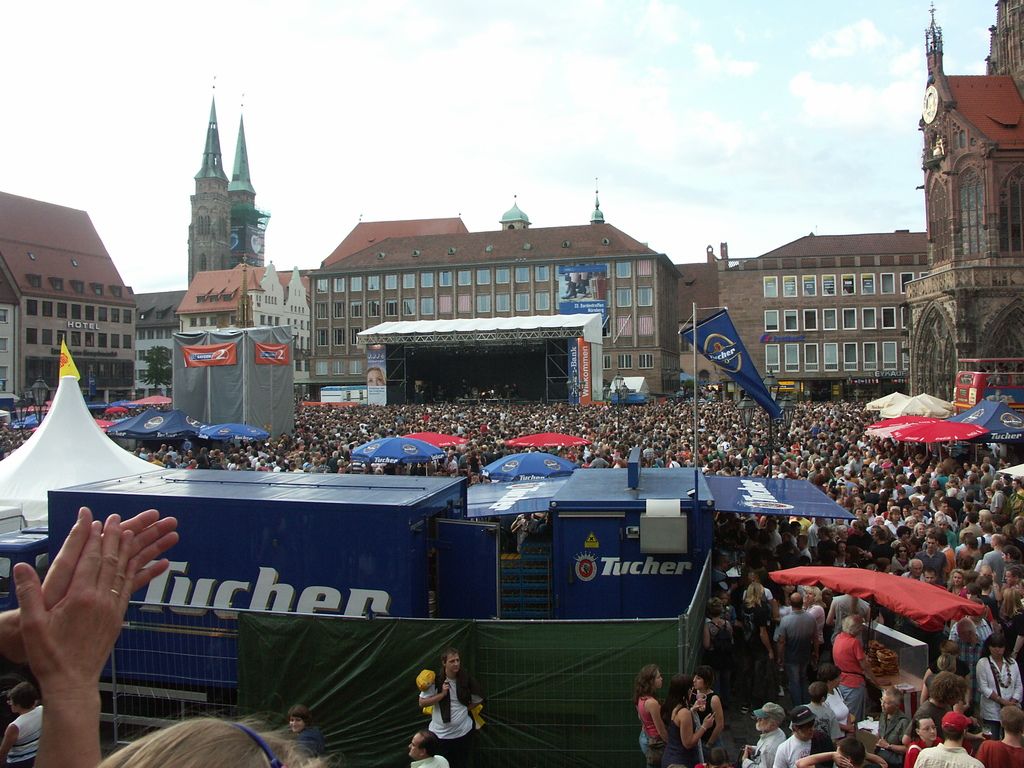 Buildings with windows. Here we can see a crowd, banner and umbrellas.