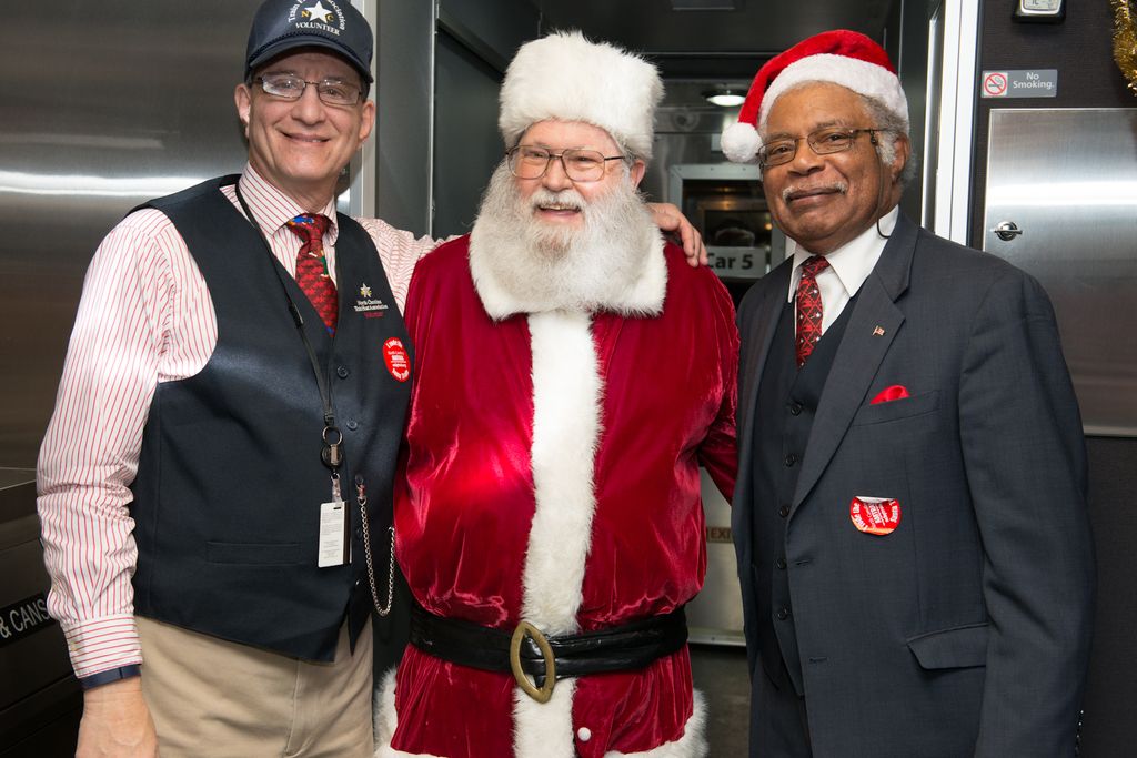 In this image, we can see people standing and wearing glasses, caps, ties, id cards and badges and...