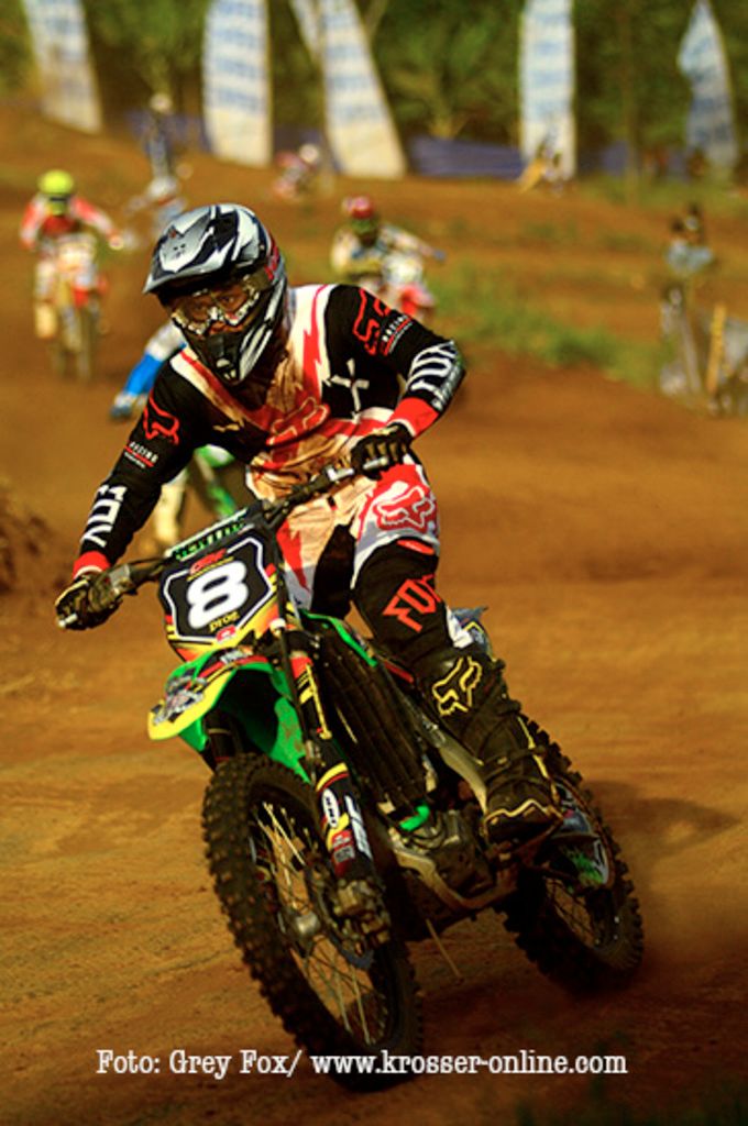 This picture looks like motorbike race. We see few people riding bikes and they wore helmets on...