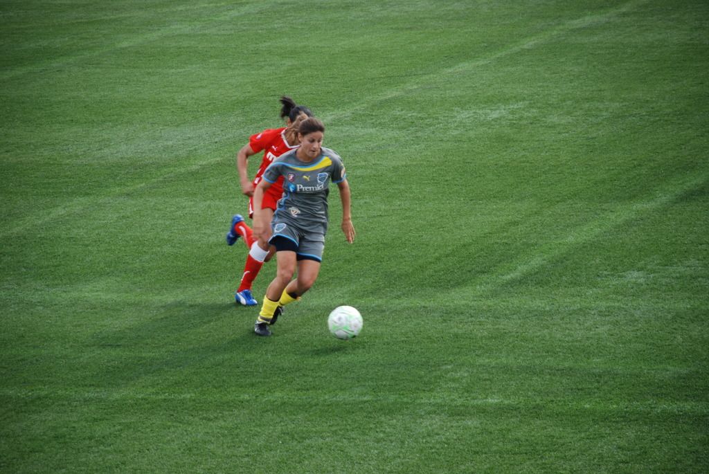 In this image we can see women and ball on the ground.