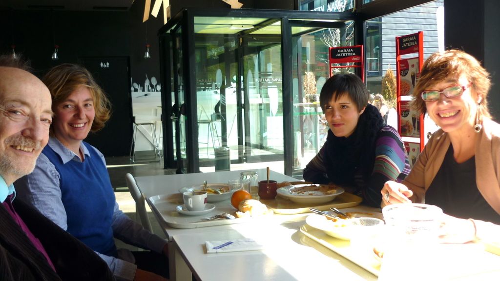 In this picture there are group of people, they are sitting around the table to the right and left...