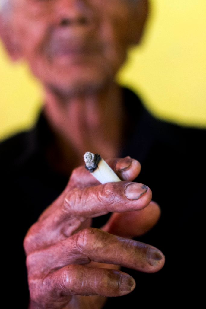 In this image we can see a person holding a cigarette in his hand.