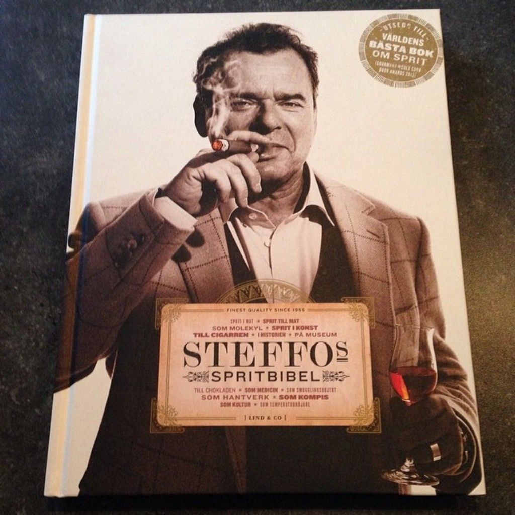 It is an image on the book in black and white, in this a man is smoking he wore coat, shirt.