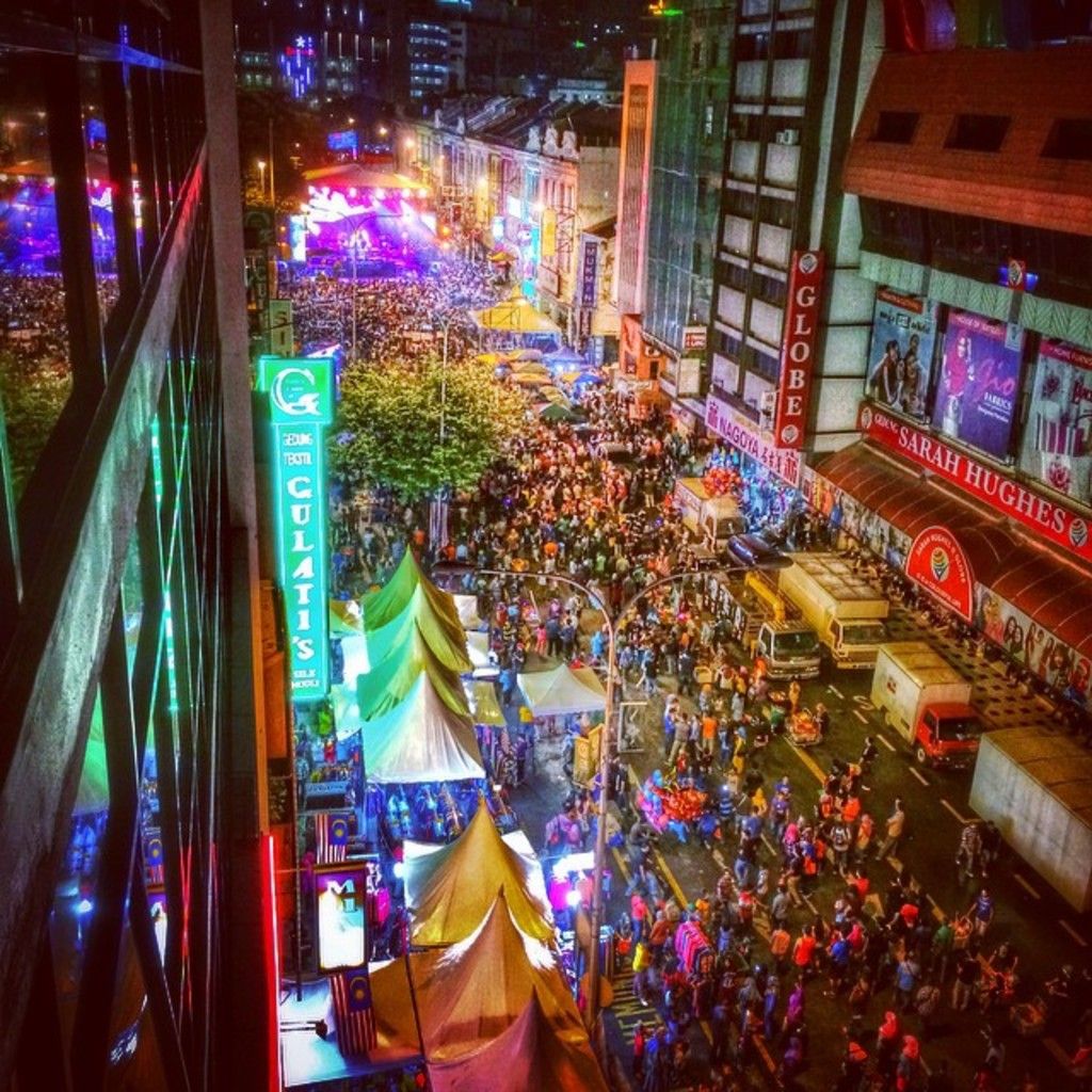 In the image it looks like some carnival, there is a huge crowd on the road and around them there...