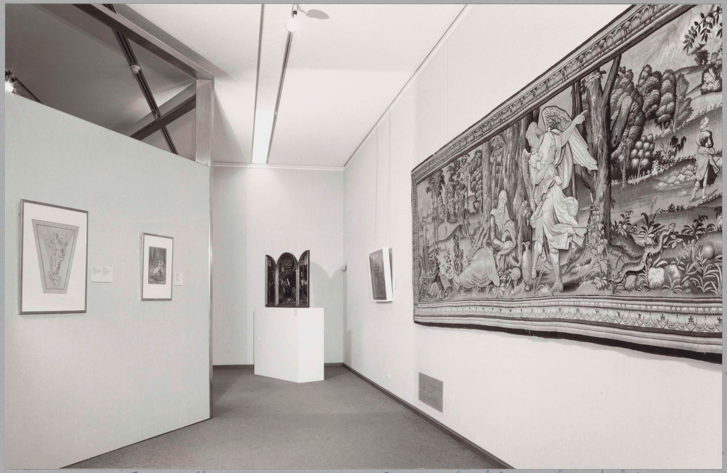The image shows a black and white photo of a room with a large tapestry hanging on the wall, photo...