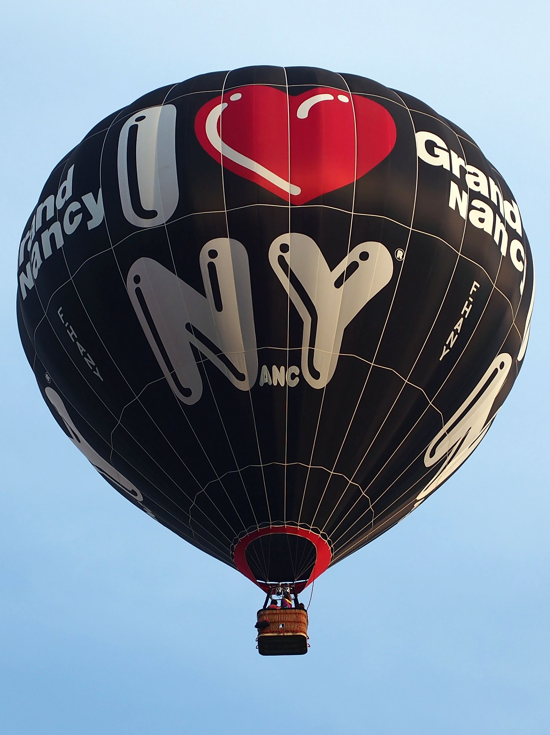 The image shows a hot air balloon with the words "I Love NYC" written on it, floating in the sky....