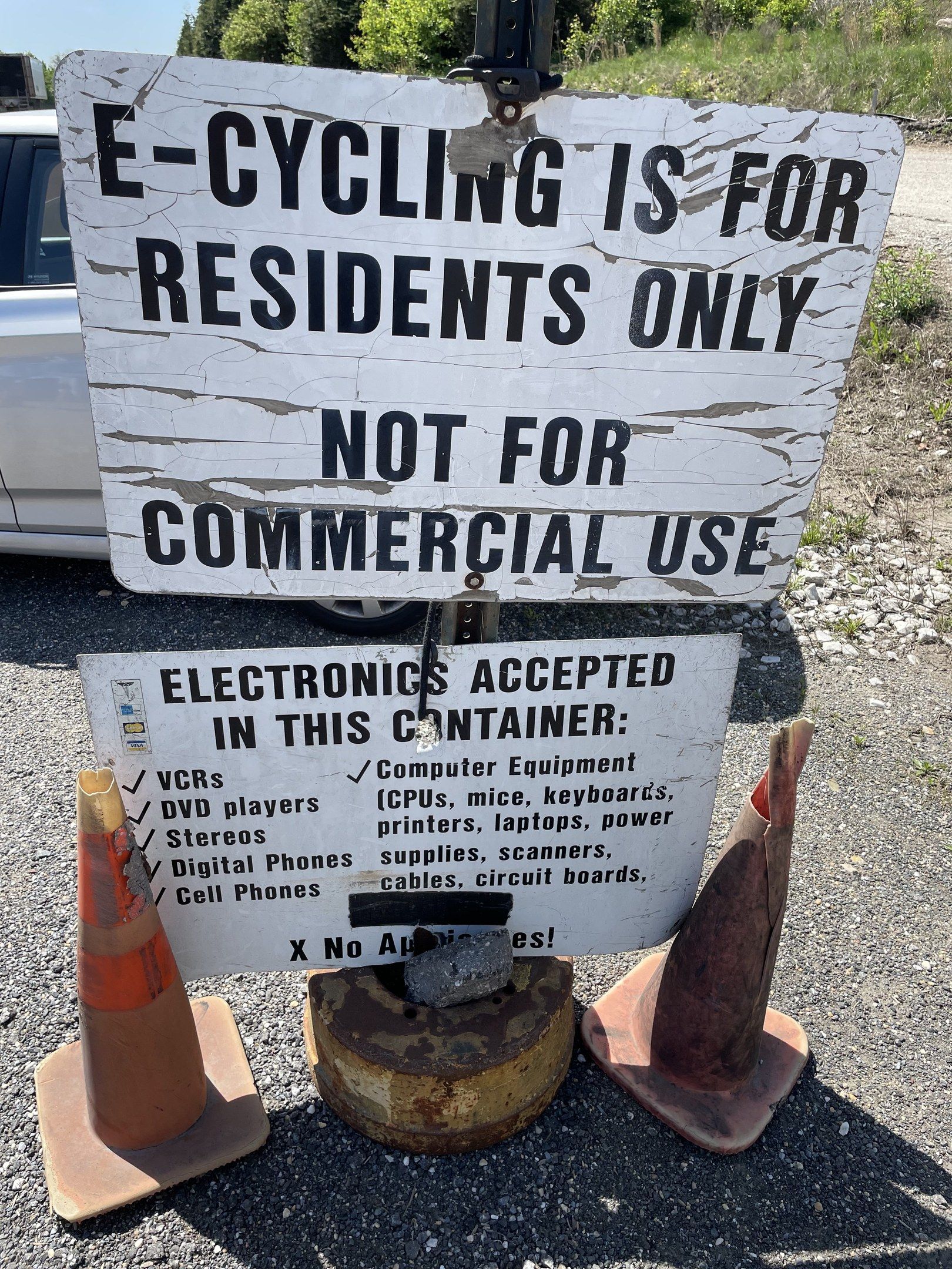 The image shows a sign that reads "e-cycling is for residents only" sitting on the side of a road,...