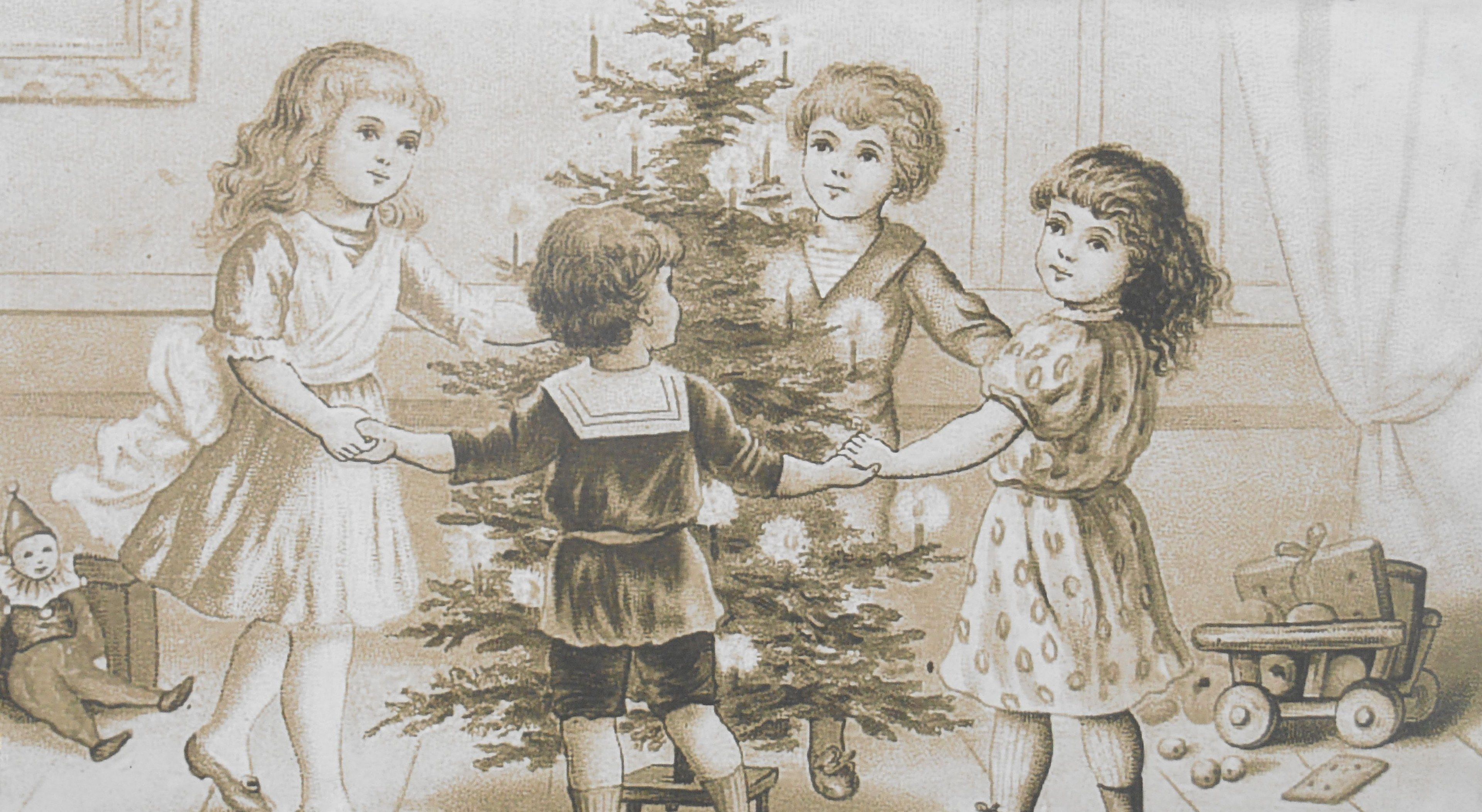 The image shows a group of children standing around a Christmas tree, with a trolley filled with...