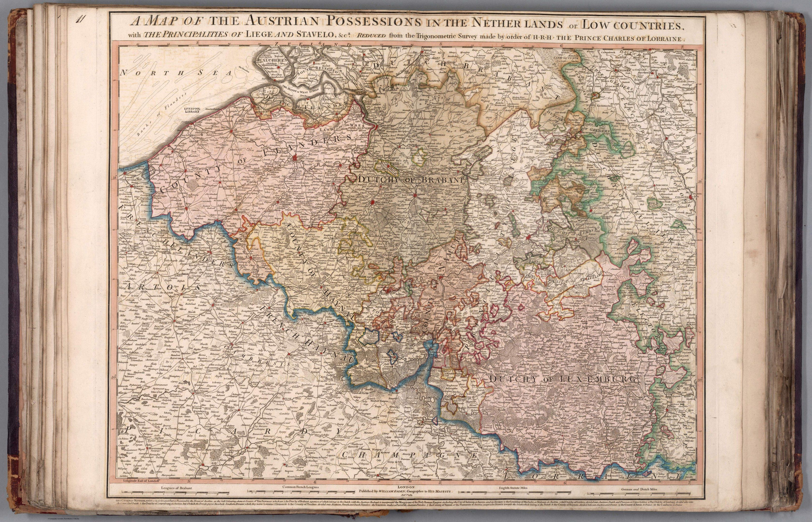 The image shows an open book with a map of the Austrian possessions in the Netherlands and Low...