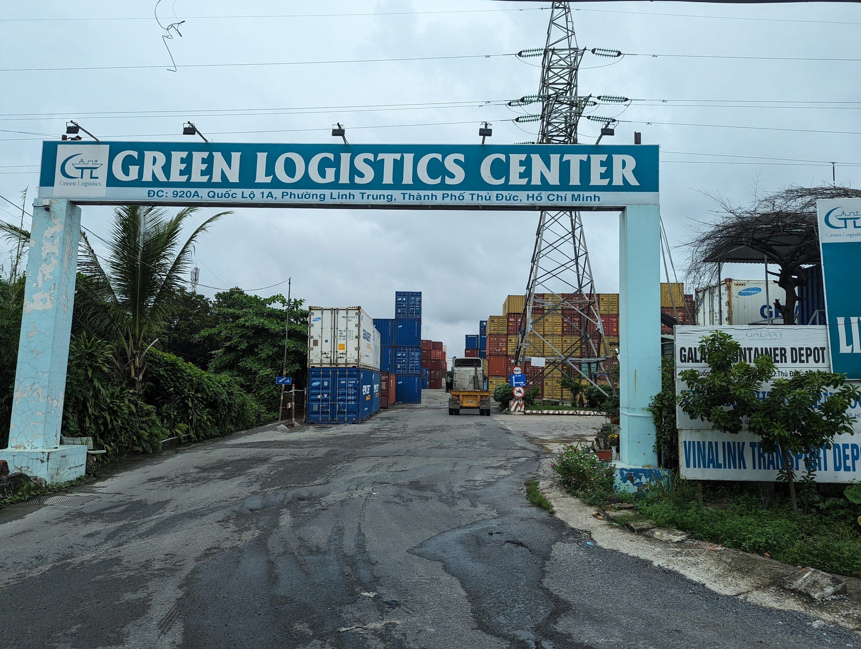 The image shows the entrance to the Green Logistics Center in Ho Chi Minh City, Vietnam. There is...