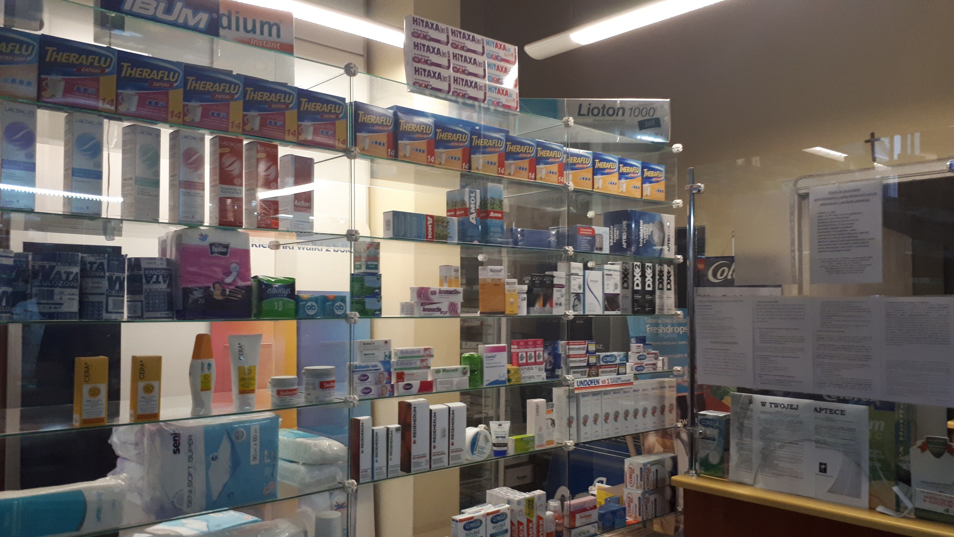 The image shows a pharmacy with a display case filled with lots of different types of medicines,...