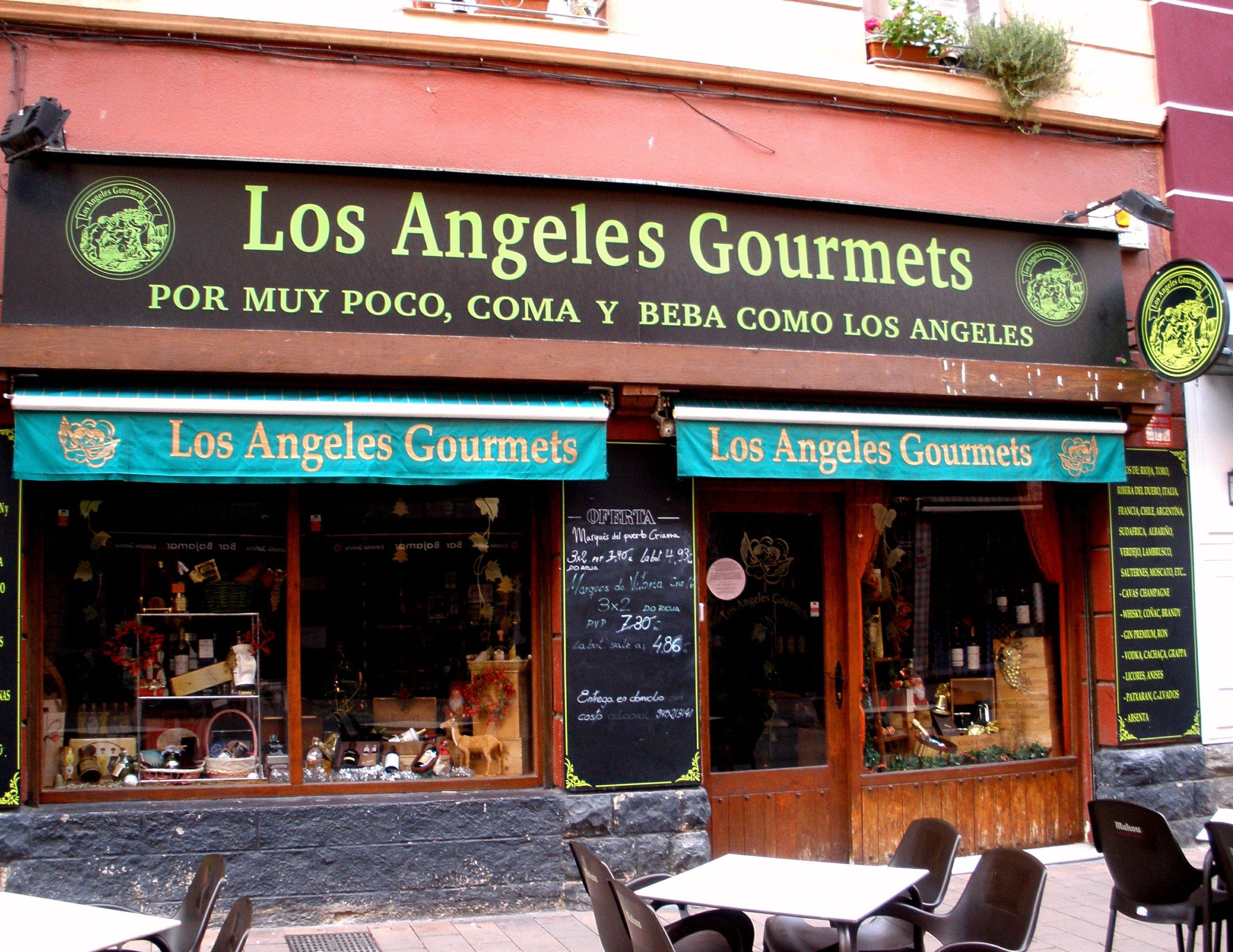 The image shows a restaurant called Los Angeles Gourmets in Madrid, Spain. There are tables and...