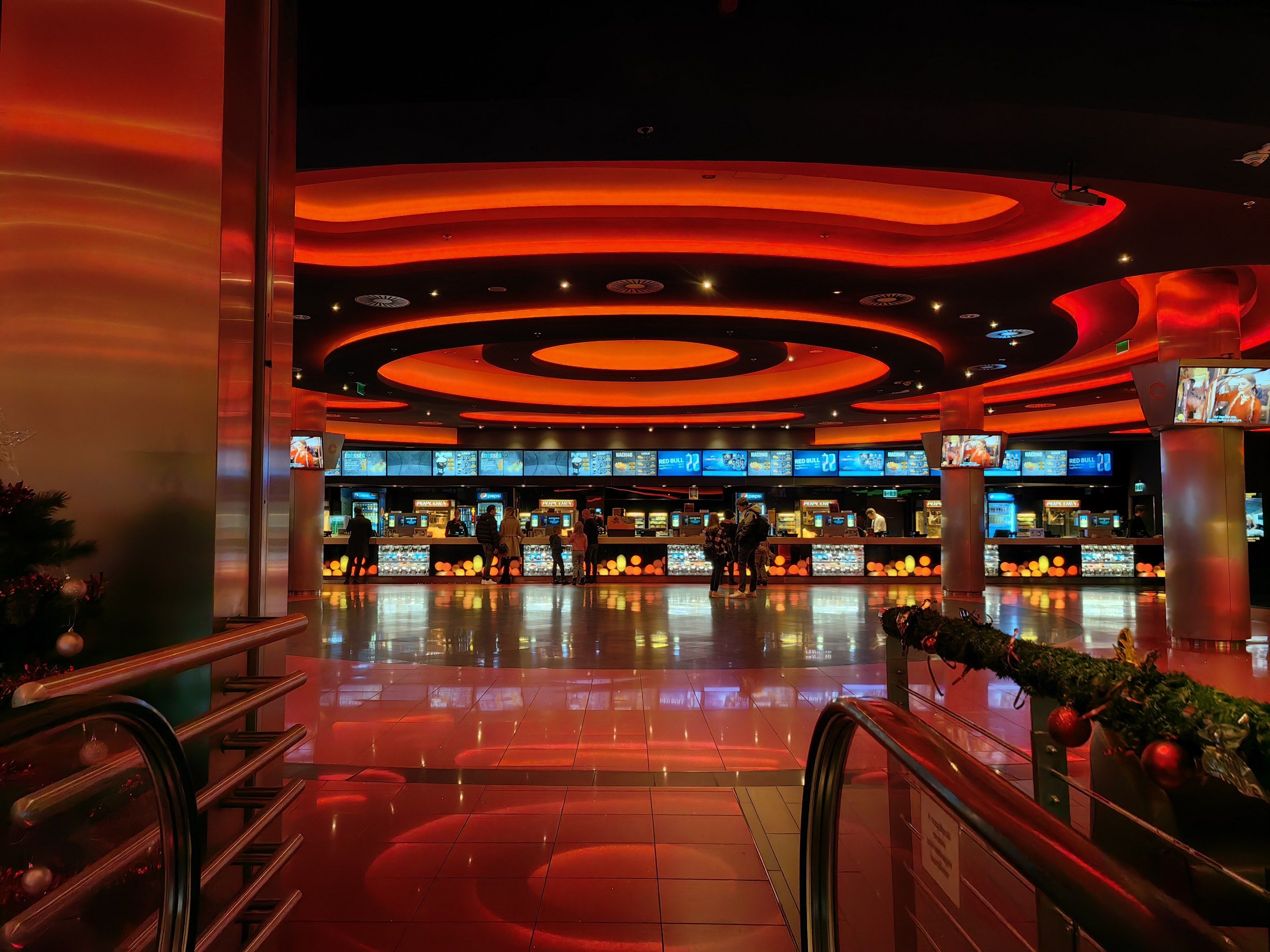 The image shows the inside of a casino with a Christmas tree in the middle of it. The floor is...