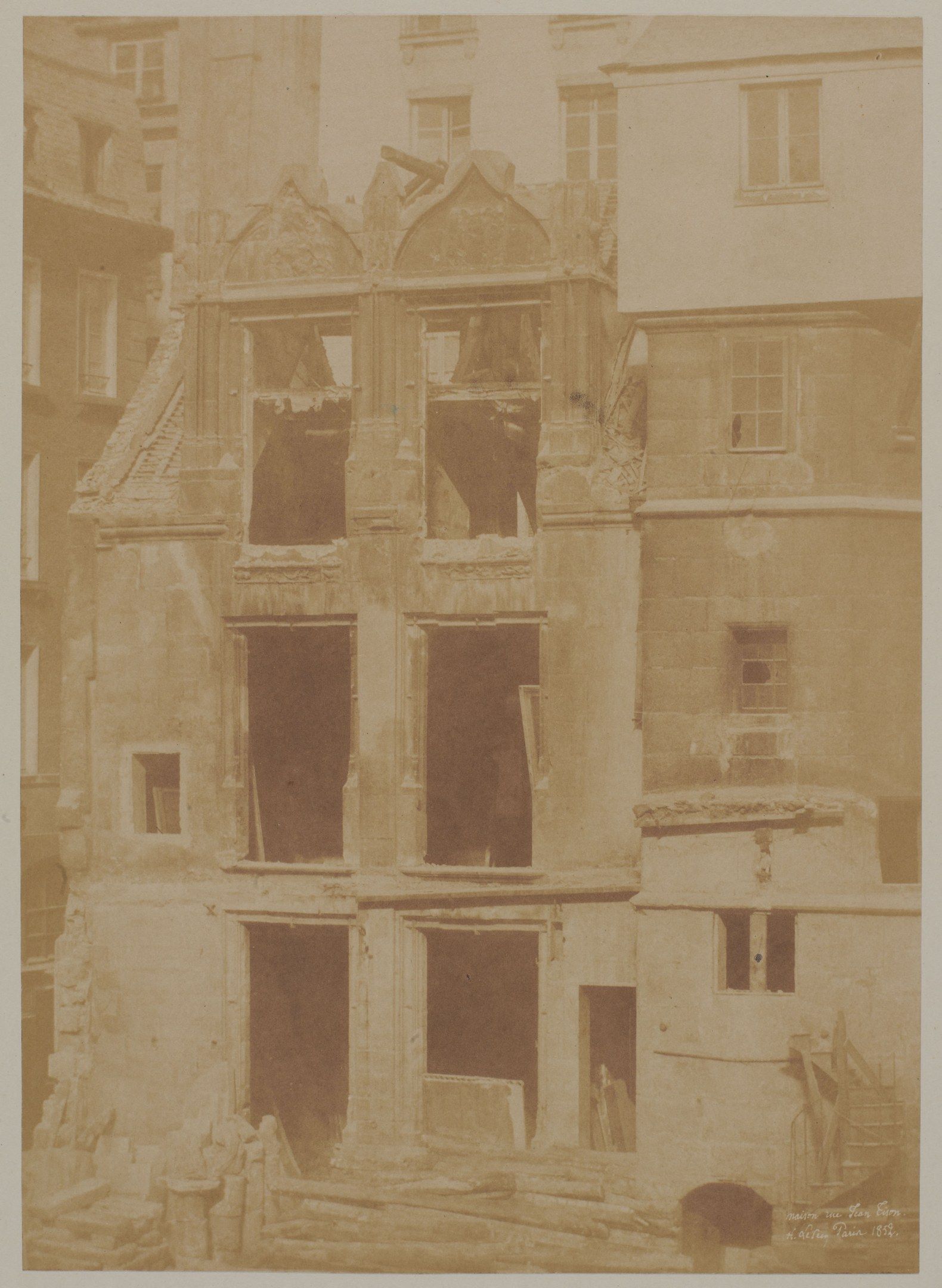 The image shows an old photo of a building with a lot of windows, and at the bottom of the image...