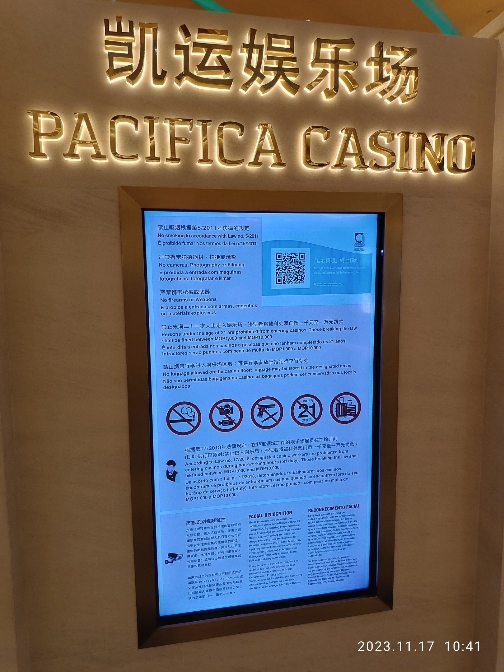 The image shows a sign that reads "Pacifica Casino" on the side of a building, with a screen on the...
