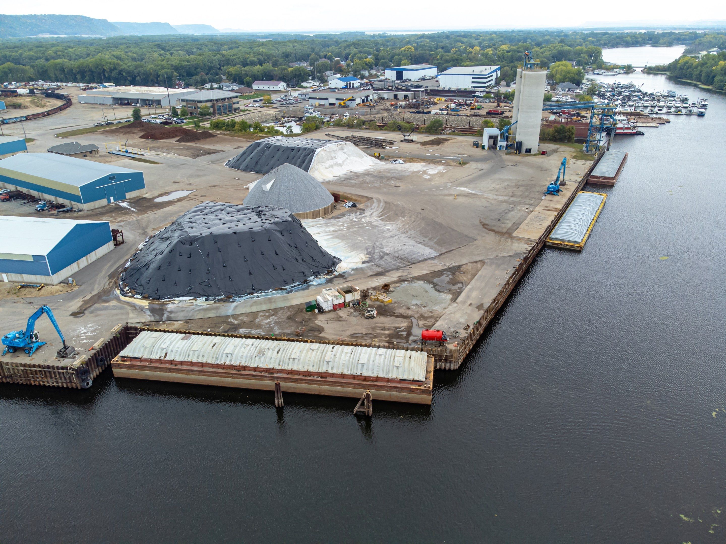 The image shows an aerial view of a large body of water with a dock in the middle, surrounded by...