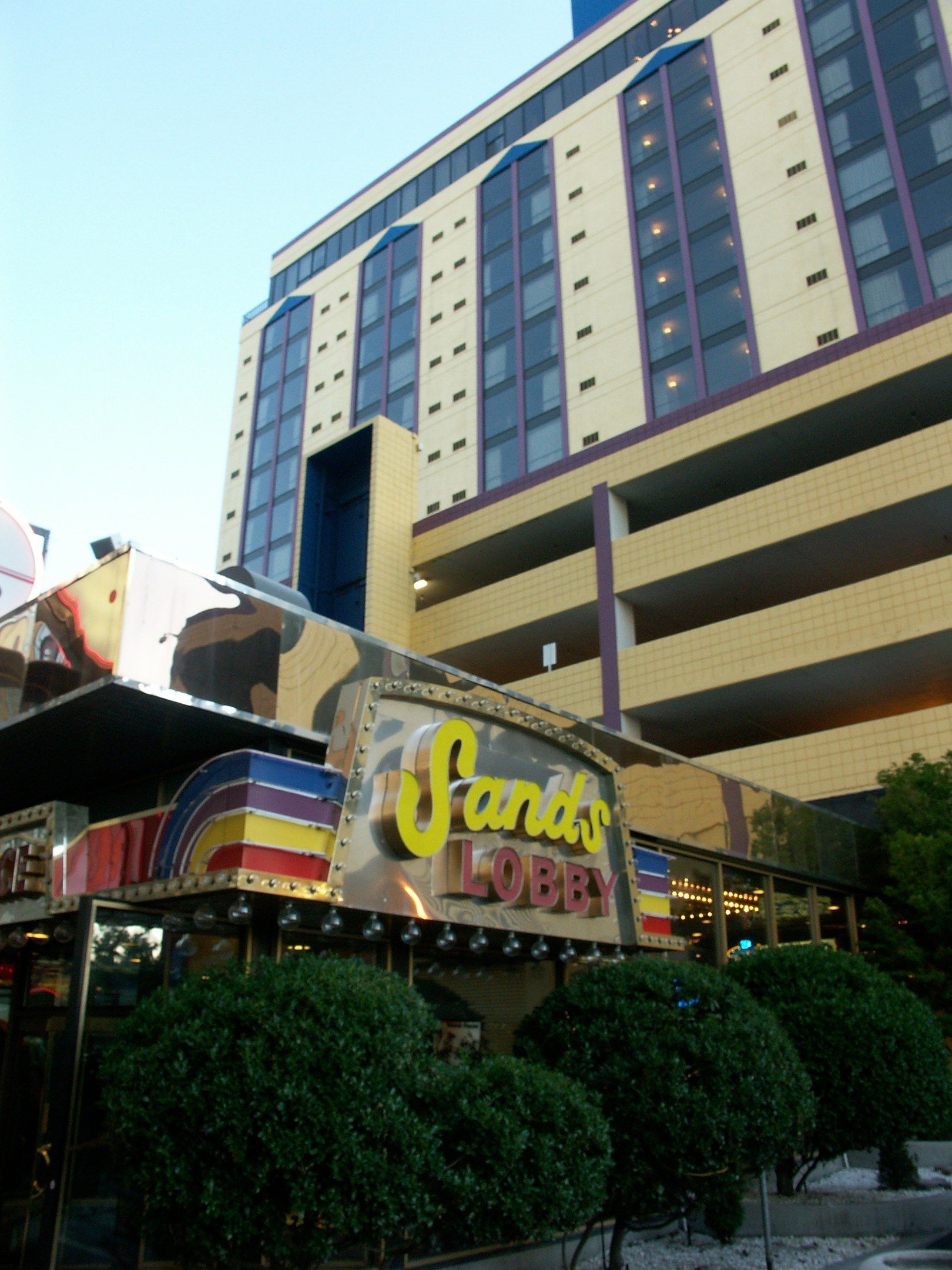 The image shows the Sands Hotel and Casino in Las Vegas, Nevada. It is a large building with glass...