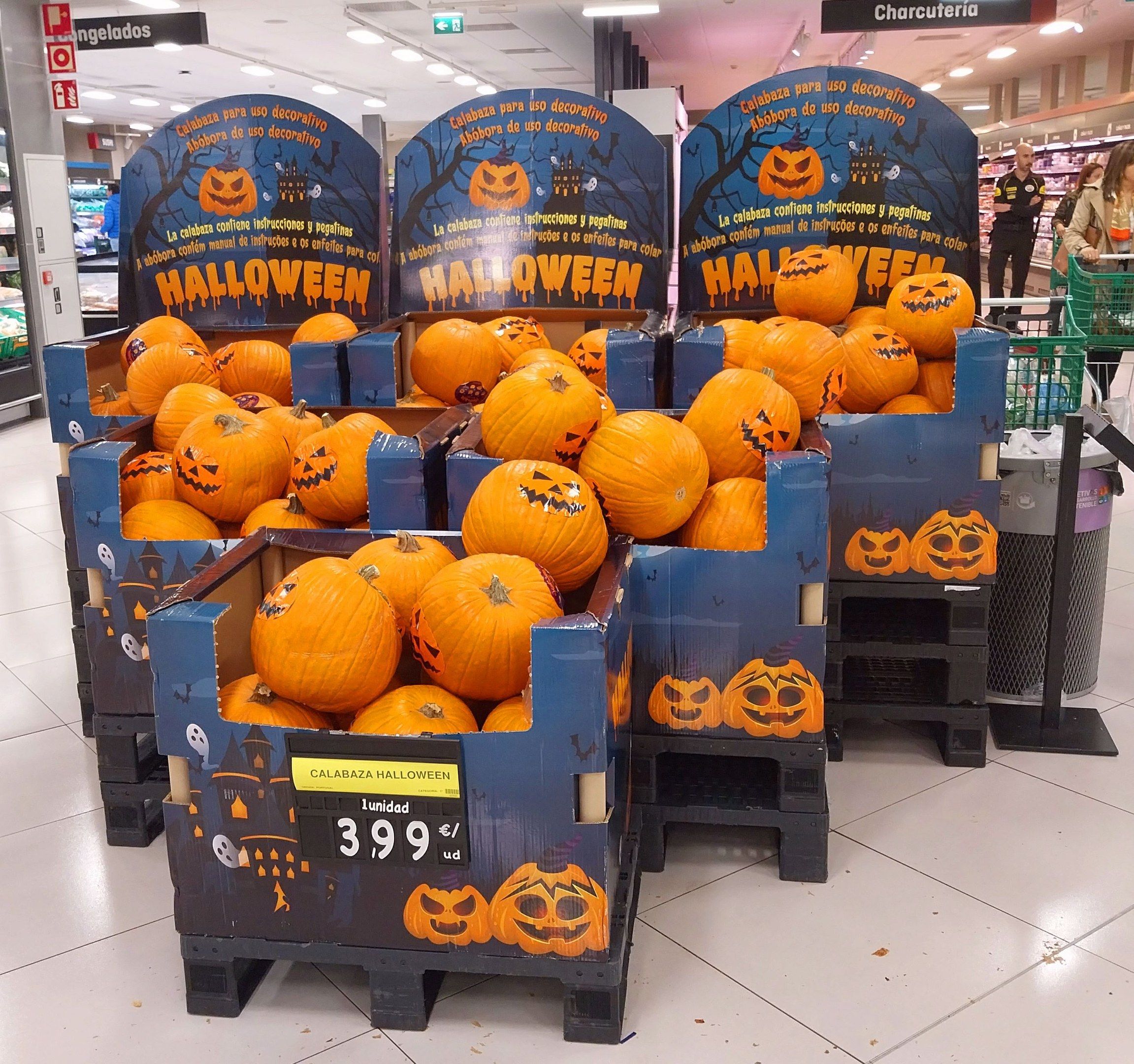 The image shows a store filled with lots of pumpkins on display. There are cardboard boxes with...