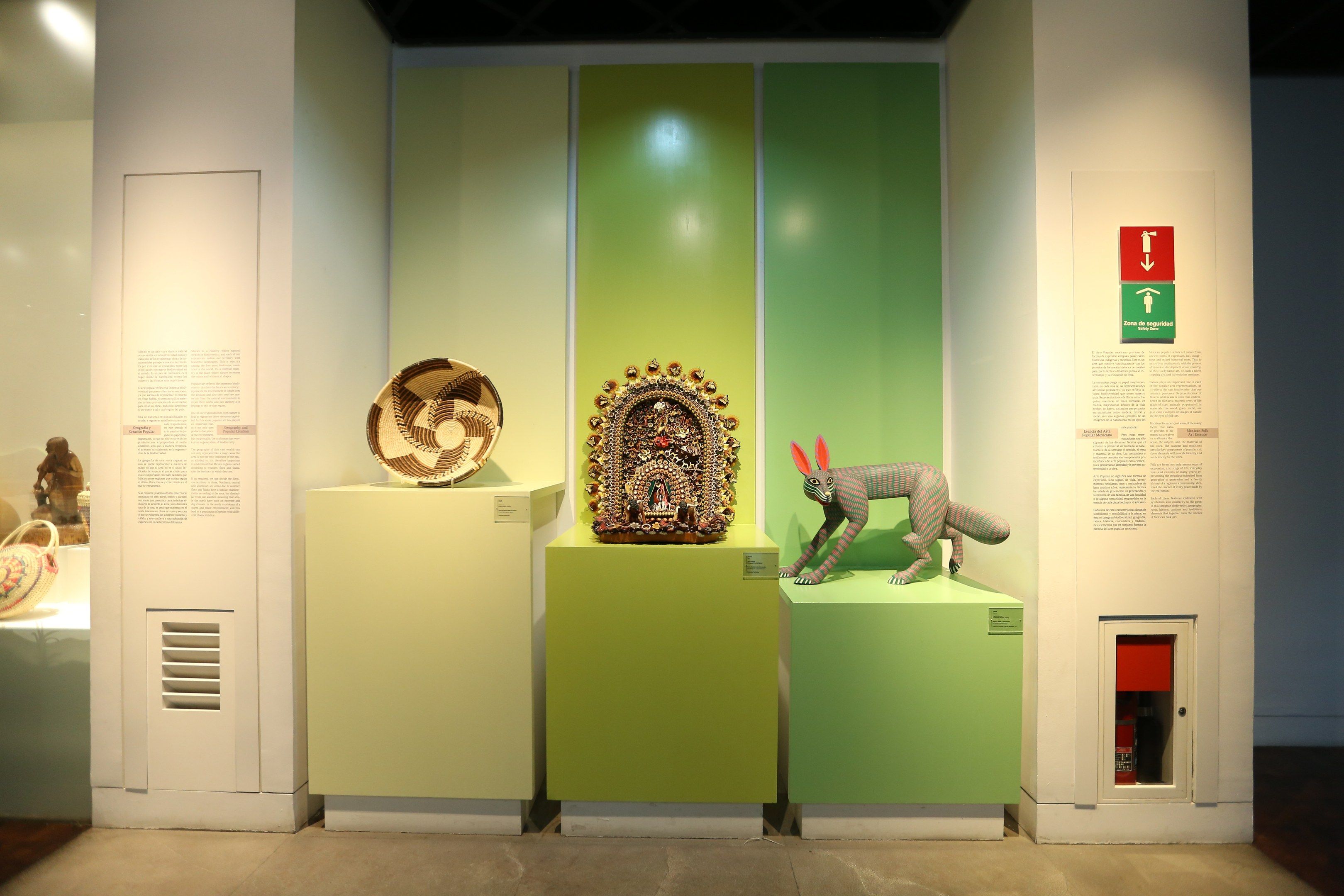 The image shows a room filled with lots of different types of art on display, including sculptures...