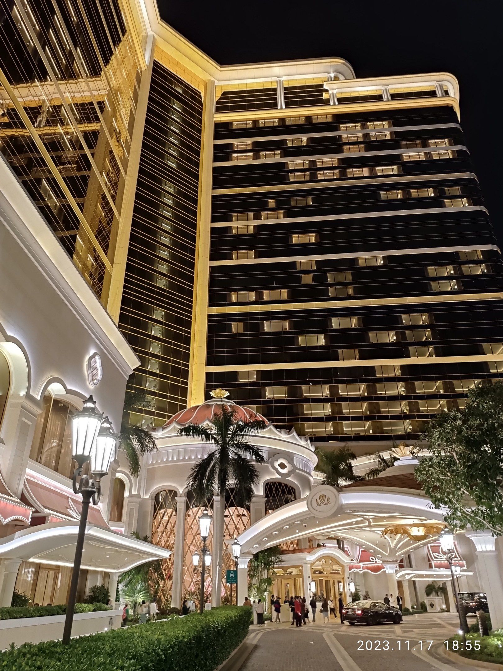 The image shows the Wynn Hotel and Casino in Las Vegas, Nevada. It is a large building with glass...