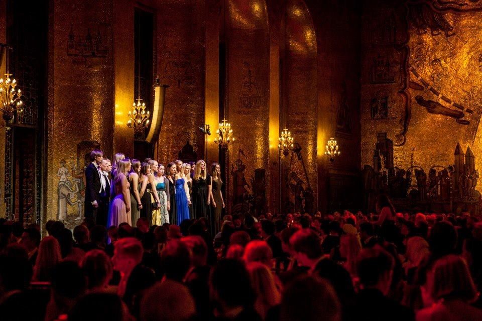 The image shows a group of people standing on top of a stage at the Royal Opera House in London....