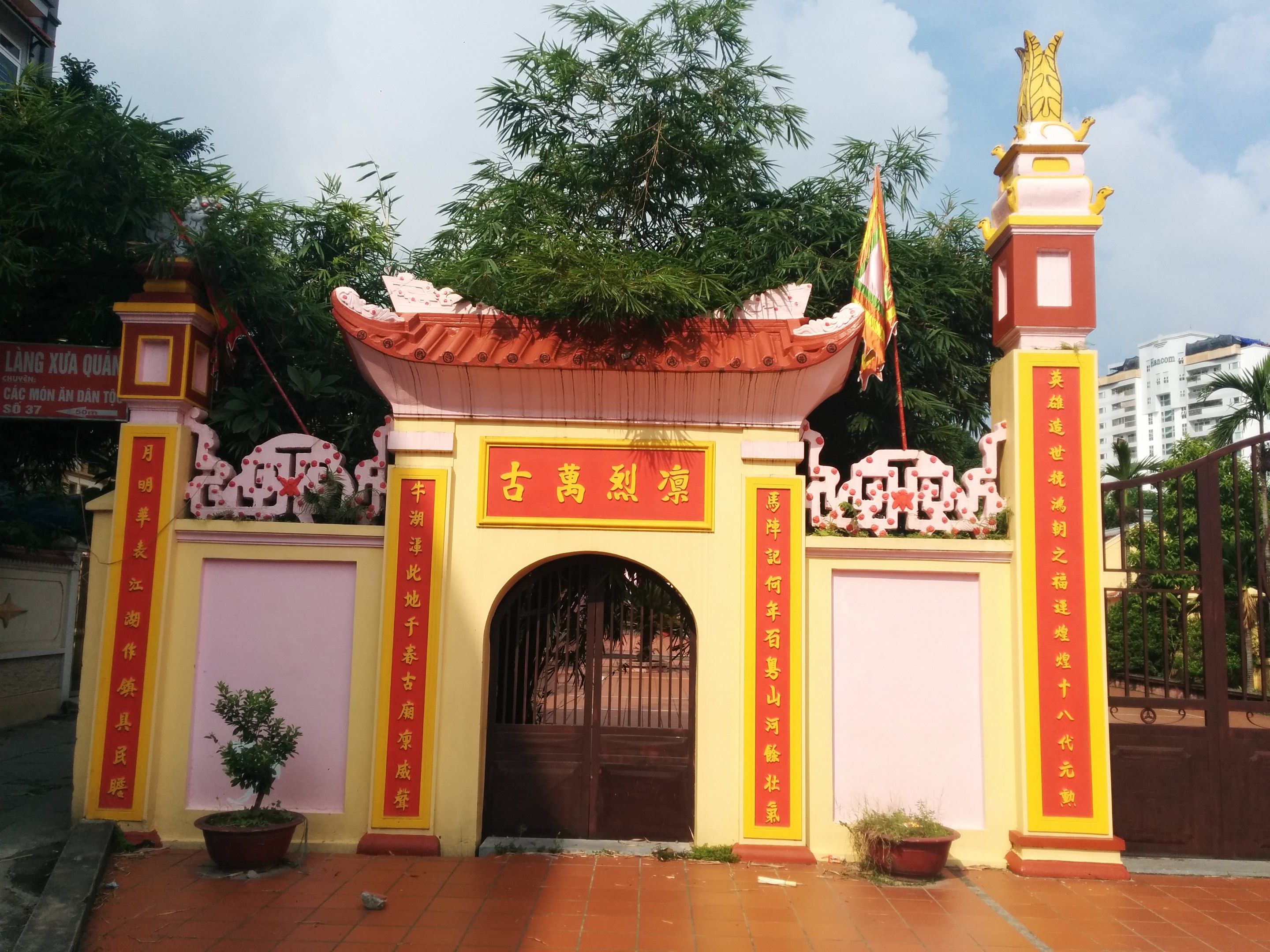 The image shows the entrance to a Chinese temple in Ho Chi Minh City, Vietnam. It is an arch with a...