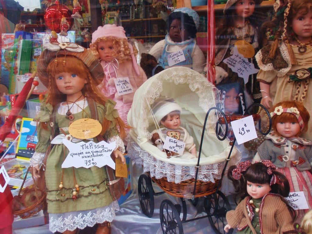 In the image in the center we can see few barbie toys in different colorful dresses. And we can see...
