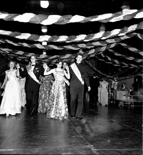 The image shows a group of people dancing on a dance floor, illuminated by lights and decorated...