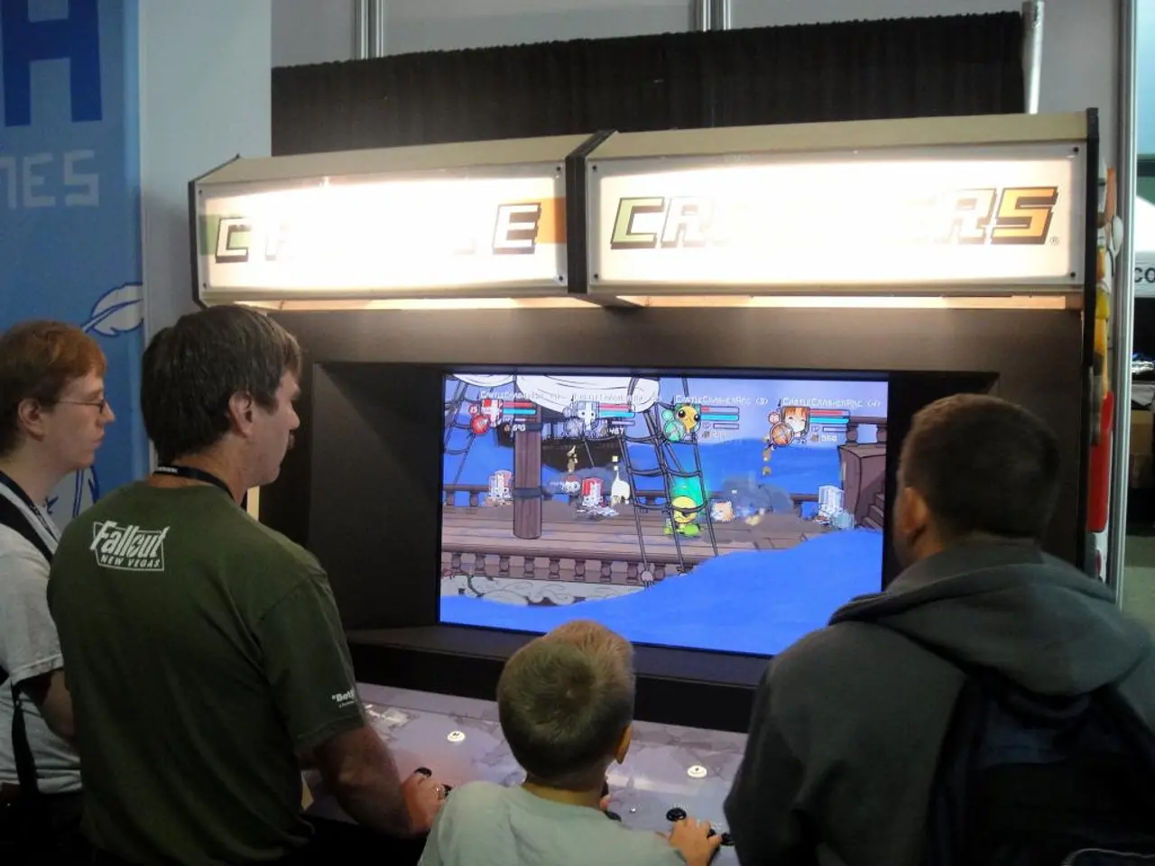 In this image we can see a boy playing the video game. We can also see three men standing and...