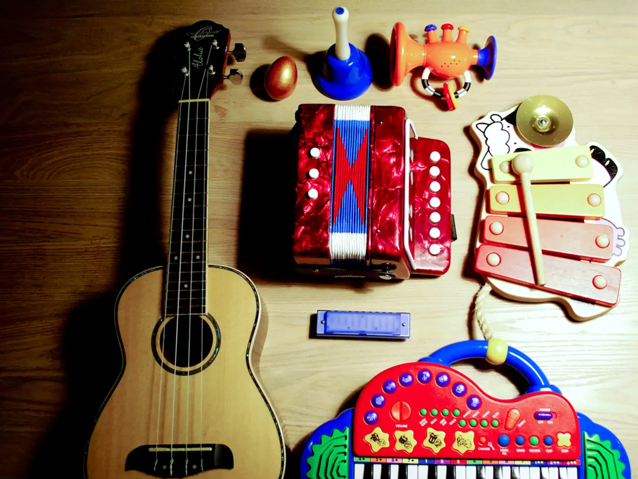 In this picture we have a guitar , a xylophone , harmonicas , a musical piano , a toy , a plastic...
