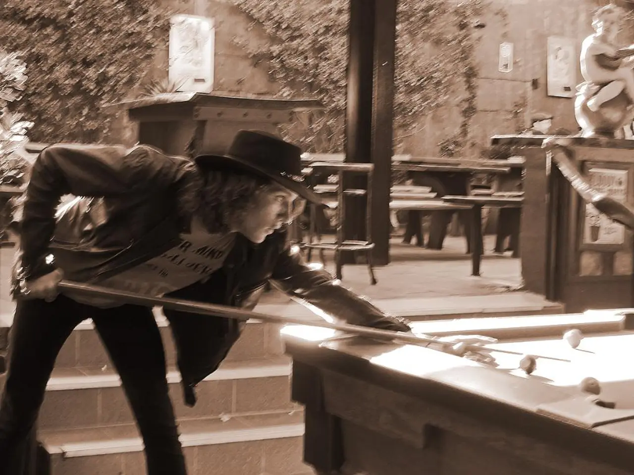 In this picture, I can see a man holding a queue in his hand and playing billiards and I can see...