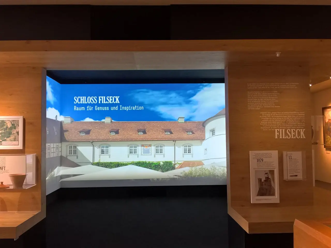 The image shows a room filled with lots of different types of art on display, including photo...