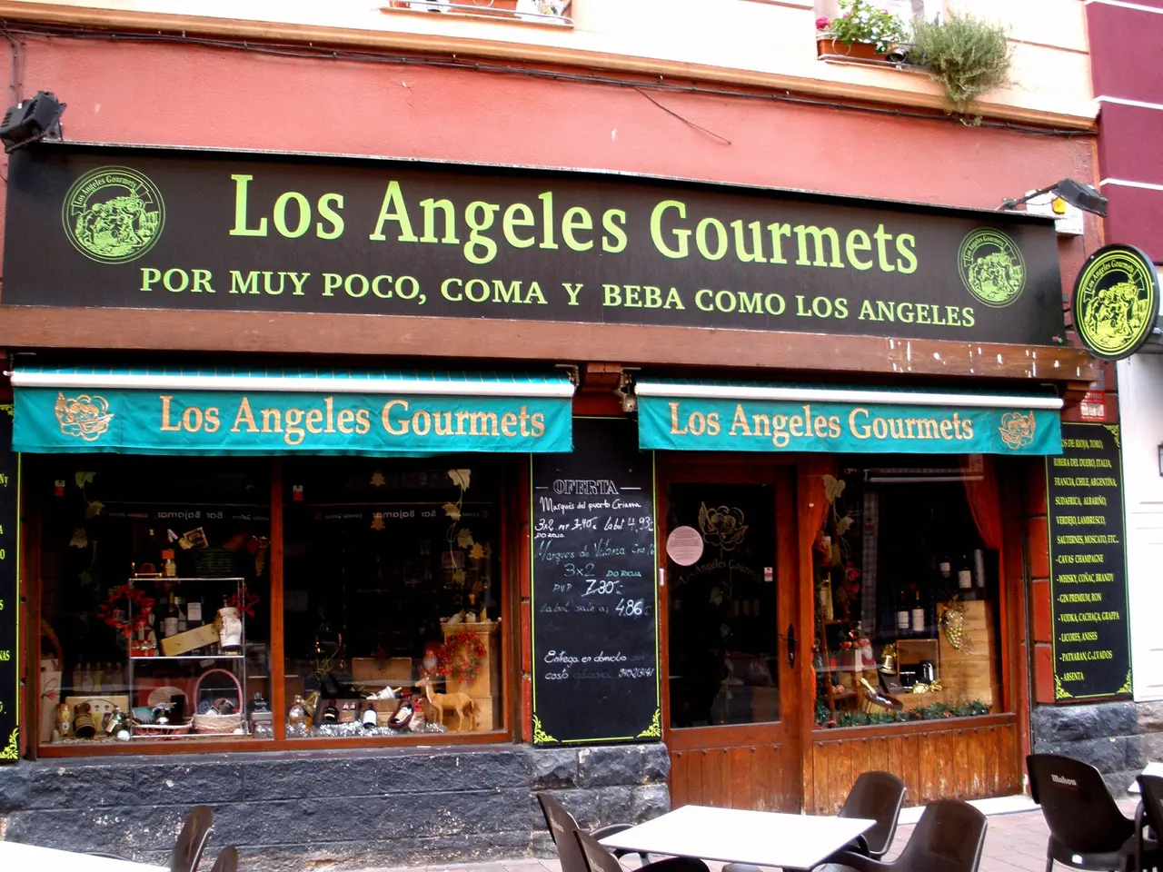 The image shows a restaurant called Los Angeles Gourmets in Madrid, Spain. There are tables and...
