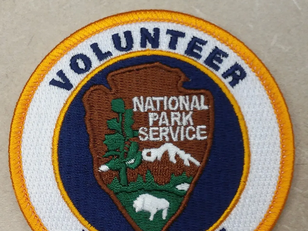 The image shows a patch with the words "Volunteer National Park Service Emeritus" written in bold...