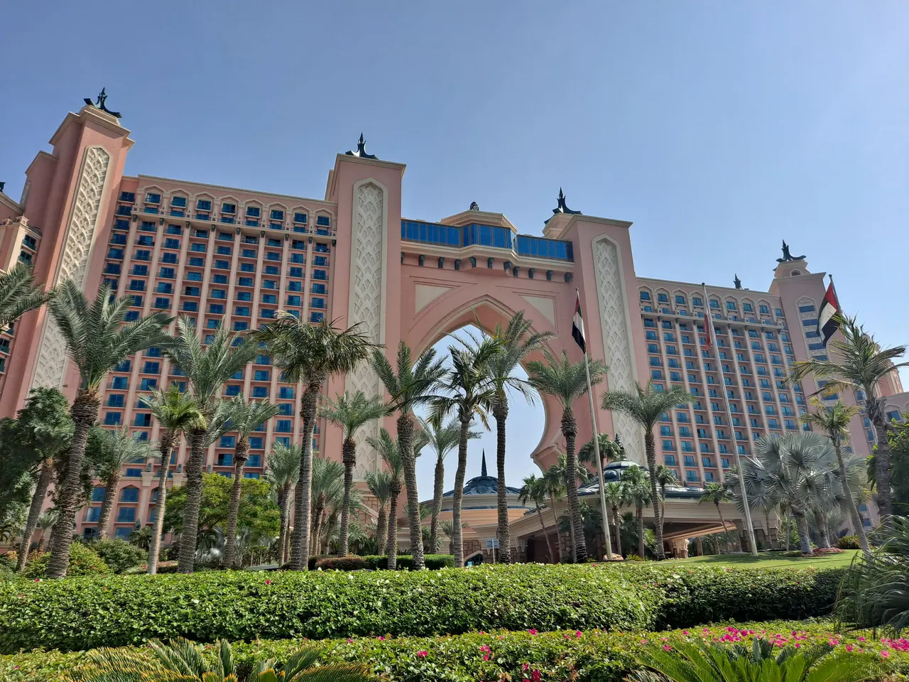 The image shows the Atlantis the Palm Hotel in Dubai, UAE. It is a large building surrounded by...