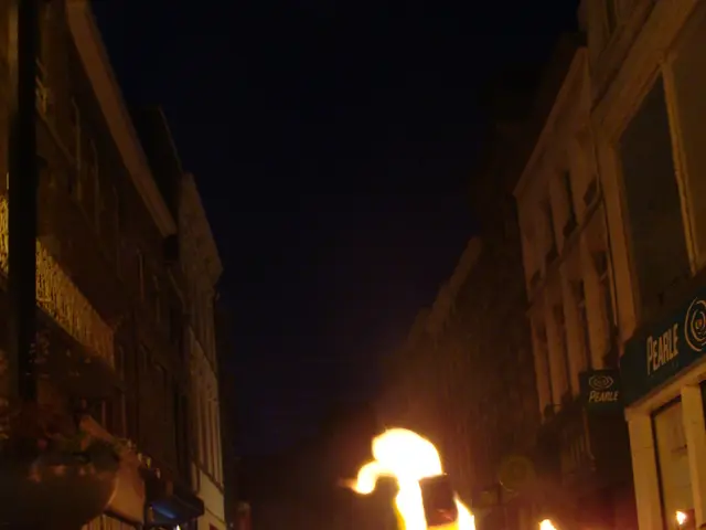 Debris from building facade collides with sidewalk and automobile