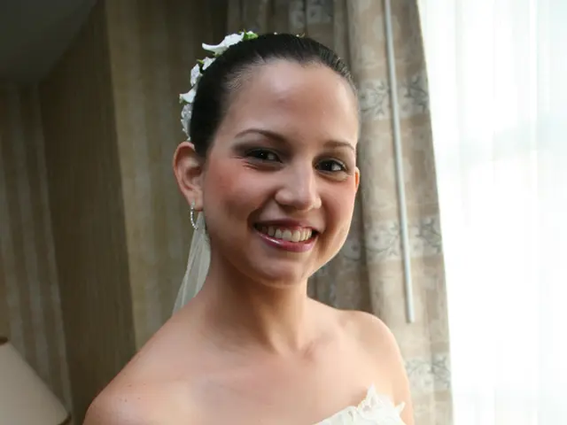 In the center of the image we can see a bride standing and smiling. She is holding a bouquet in her...