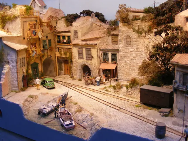 In the center of the image there are buildings. At the bottom there are boats and we can see...