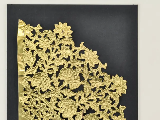 The image shows a black and gold wedding invitation with a floral design on it, set against a white...