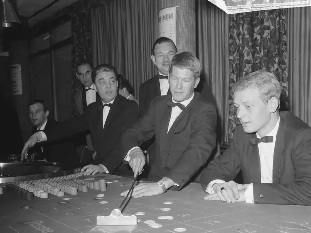 The image shows a group of men in tuxedos playing roulette at a casino table. The table is black...