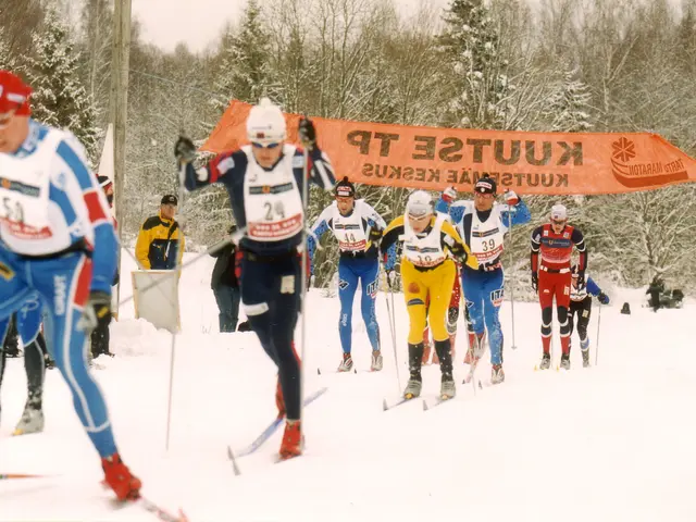 The image shows a group of people skiing down a snow covered slope, wearing caps, goggles, and...