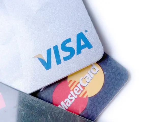 The image shows three credit cards stacked on top of each other on a white surface. The cards are...